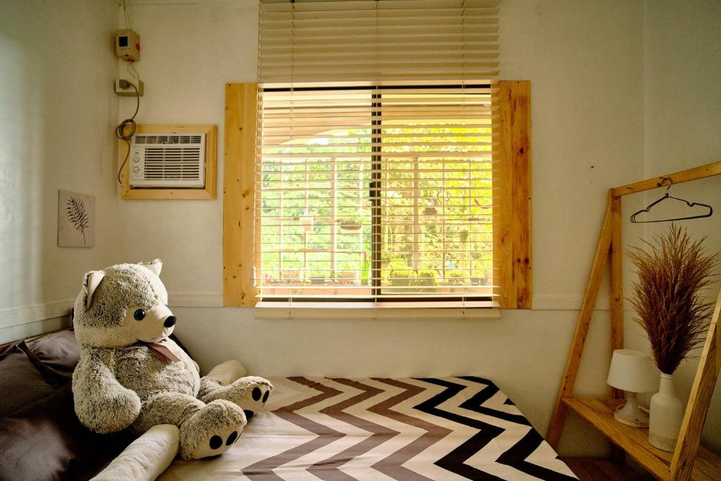 - un ours en peluche assis sur un lit dans une pièce dans l'établissement Pallet Homes - Landheights, à Iloilo