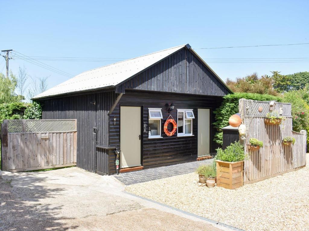 a black shed with a wreath in the window at The Old Boat Store in Totland