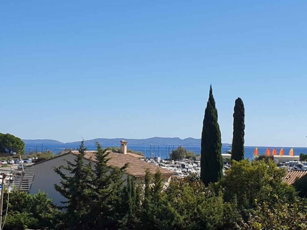 - une vue sur un parking avec des arbres dans l'établissement Studio Mezzanine vue port et mer, à La Londe-les-Maures