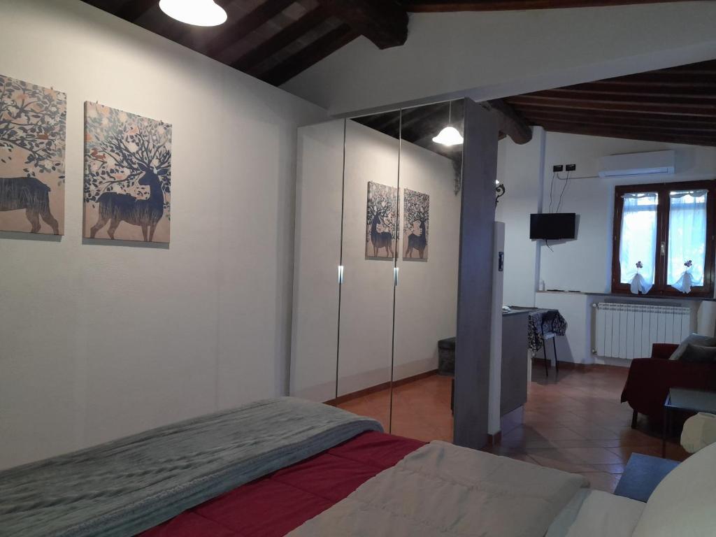 1 dormitorio con 1 cama y algunas fotos en la pared en La casa in giardino, en Volterra