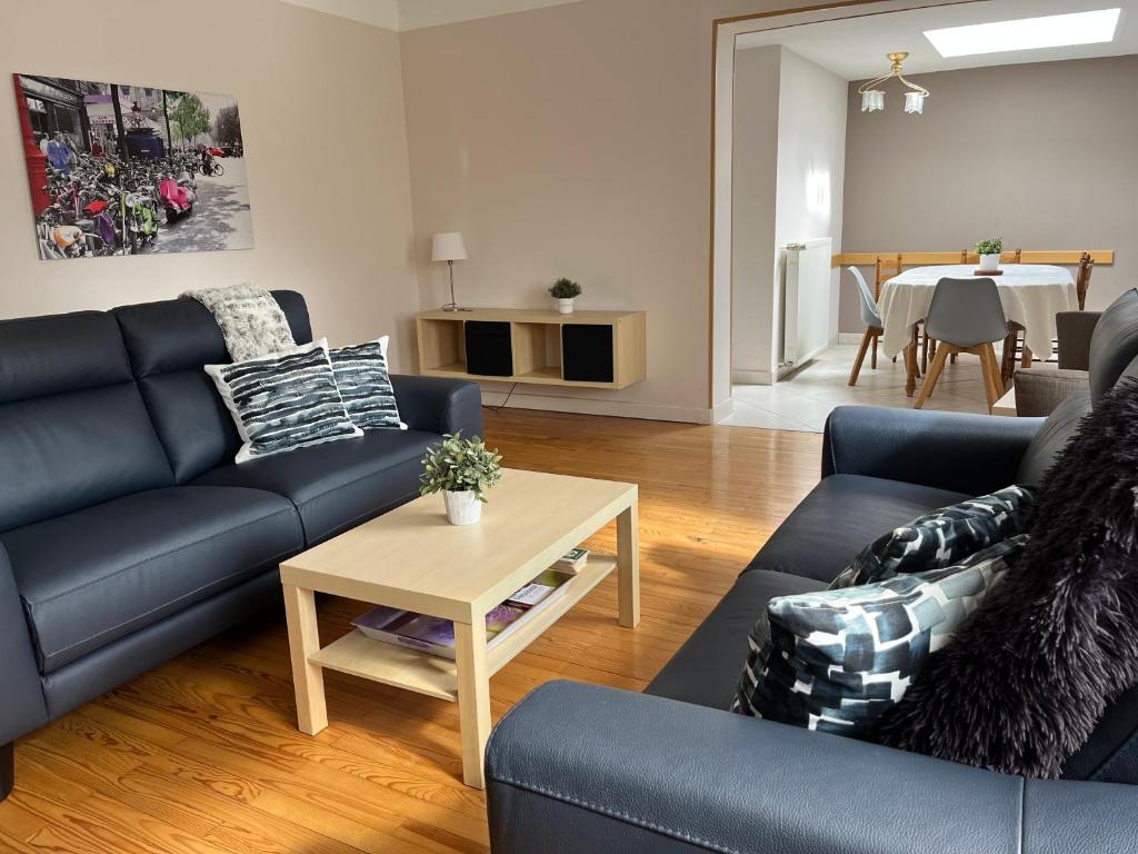 ein Wohnzimmer mit blauen Sofas und einem Tisch in der Unterkunft MAMA'S APPART in Epping-Urbach