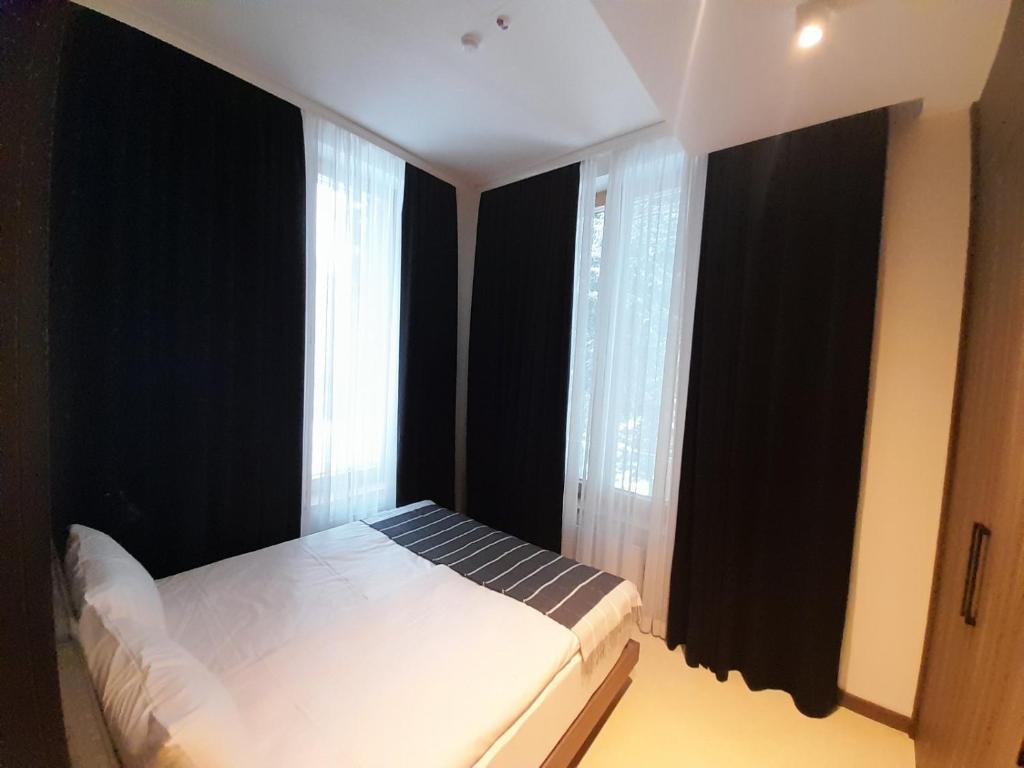 - une chambre avec un lit aux murs noirs et des fenêtres dans l'établissement Woodside Kopaonik AAC, à Raška