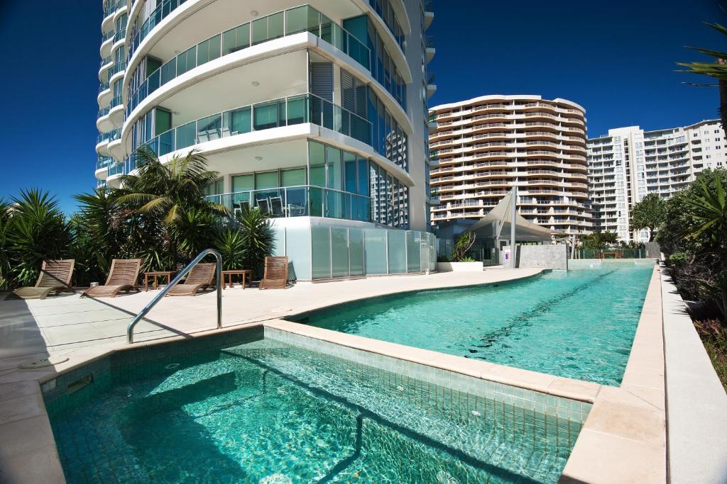 a swimming pool in front of a tall building at Reflection on the Sea in Gold Coast