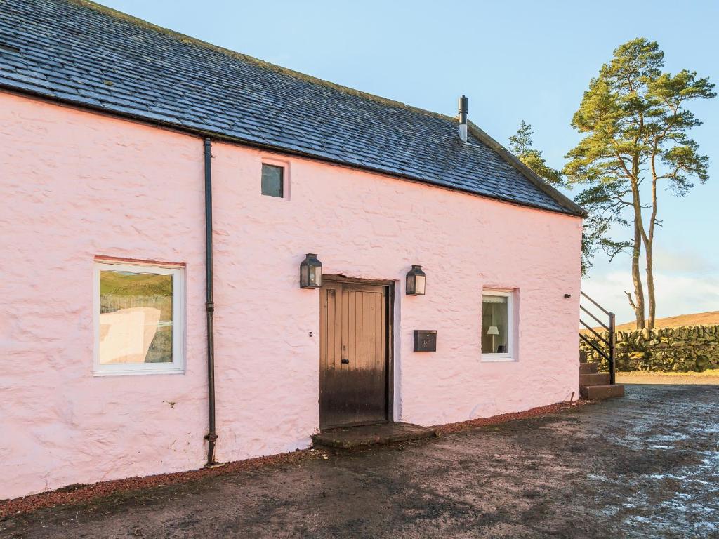 a pink building with a door in the side of it at The Granary in Crocketford