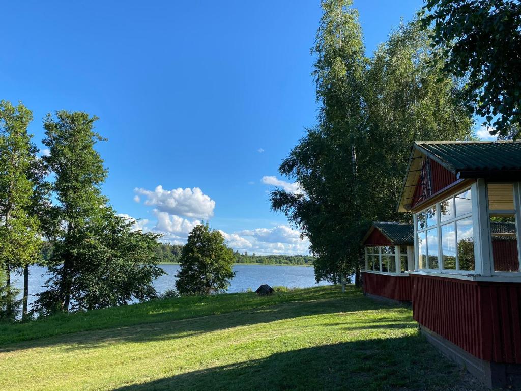 a red house with a view of a lake at Kurzemes pērle in Sepene