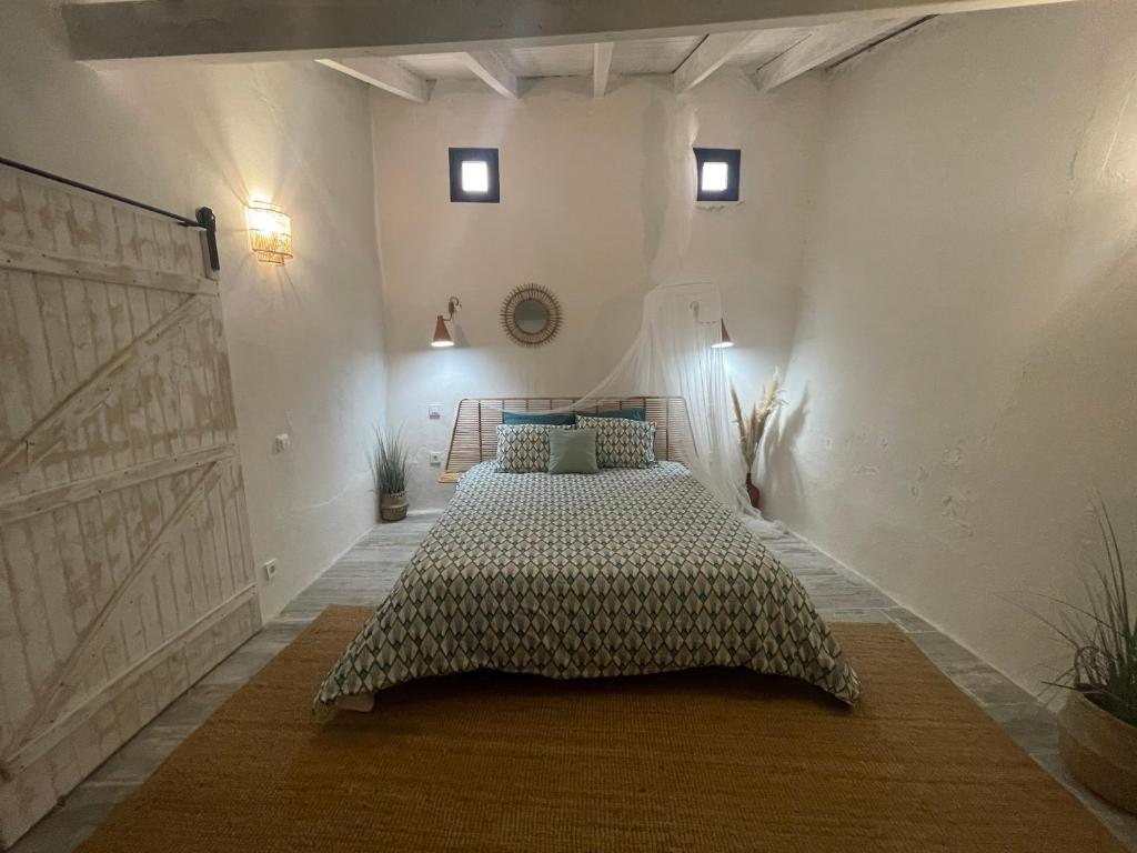 a bedroom with a bed in a white room at Casa da Estrelinha in Carrapateira