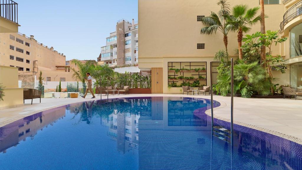 a swimming pool in front of a building at Hotel Saratoga in Palma de Mallorca