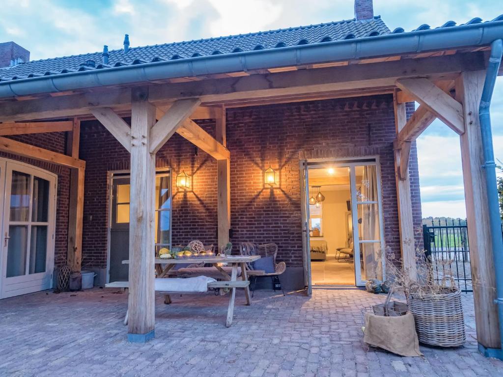een houten paviljoen met een tafel op een patio bij Gastenverblijf Bie Zus in Buggenum