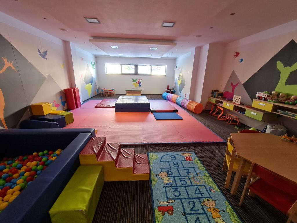 Apartmany Panorama 10X-90X في ستربشكي بليسو: غرفة مع غرفة مع صالة ألعاب مع طاولات وكراسي
