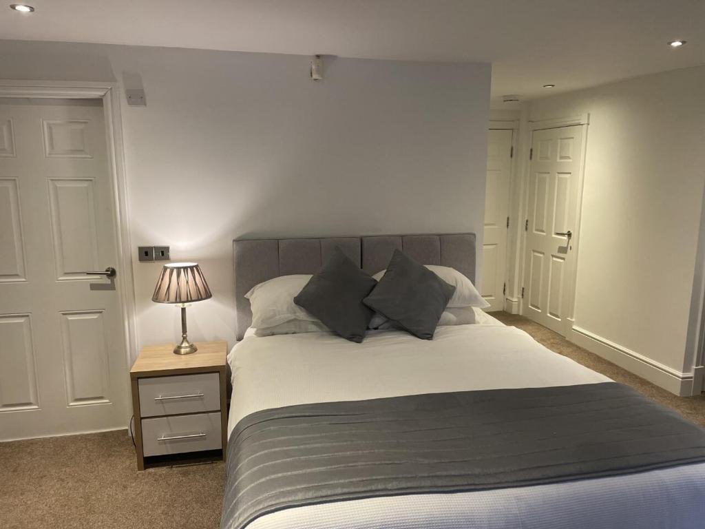 a bedroom with a bed and a lamp on a night stand at Beach House East Lodge in Southport
