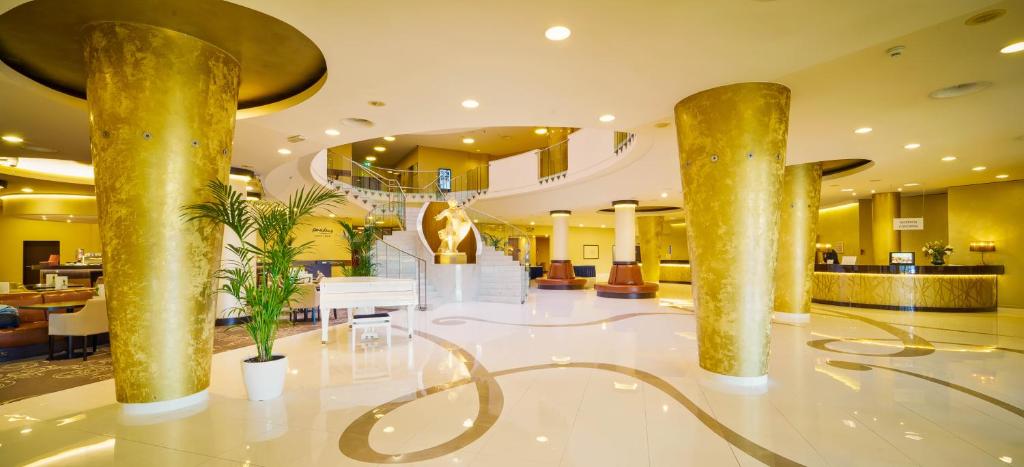a lobby with gold pillars in a hotel at Don Giovanni Hotel Prague - Great Hotels of The World in Prague