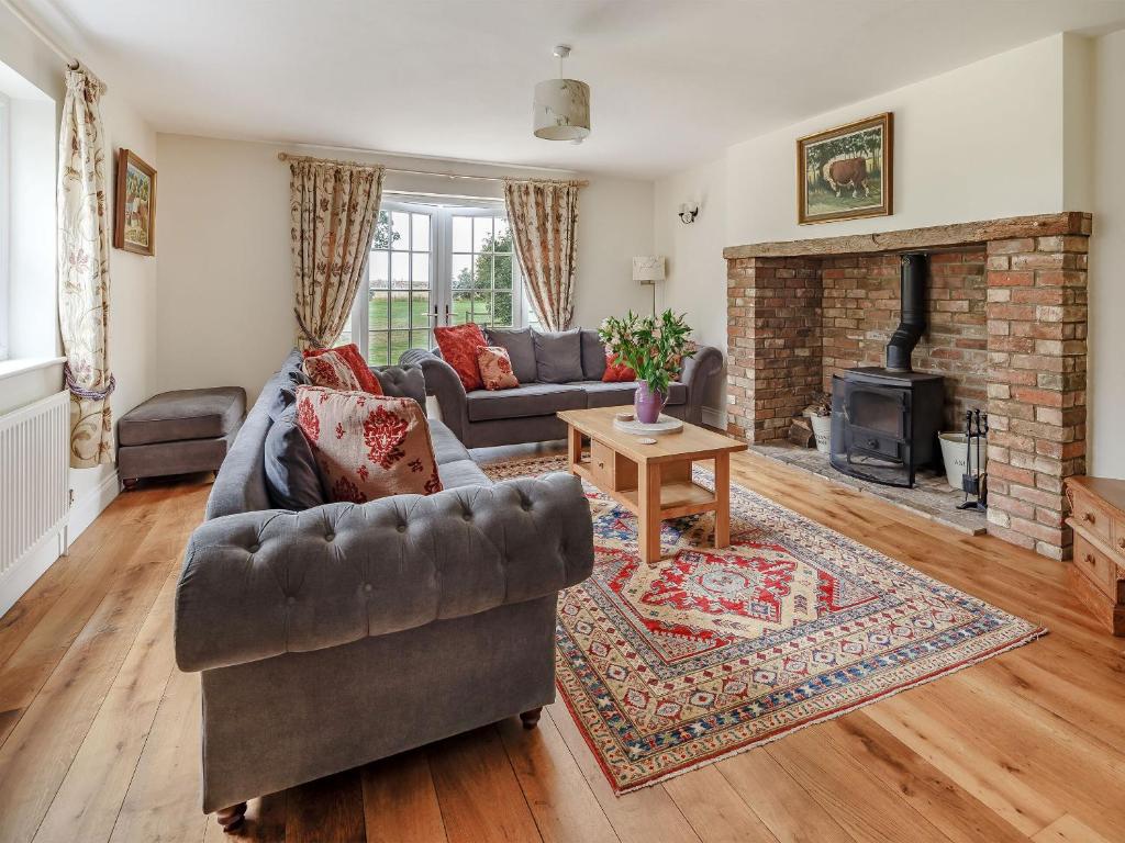 sala de estar con sofá y chimenea en Chittering Farm, en Stretham