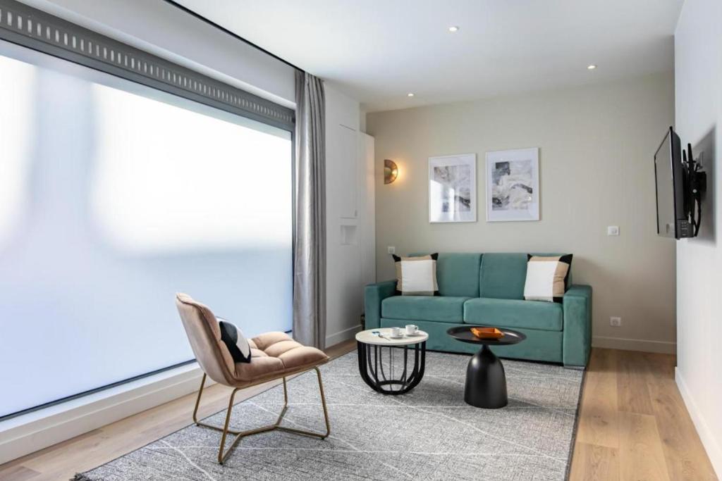 ein Wohnzimmer mit einem blauen Sofa und einem Tisch in der Unterkunft Sweet Inn - Pont Neuf in Paris
