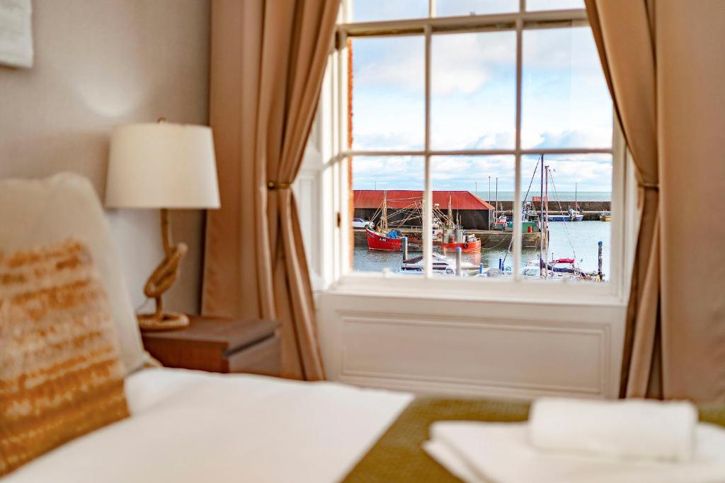 a bedroom with a window with a view of a marina at 1 Shore in Arbroath