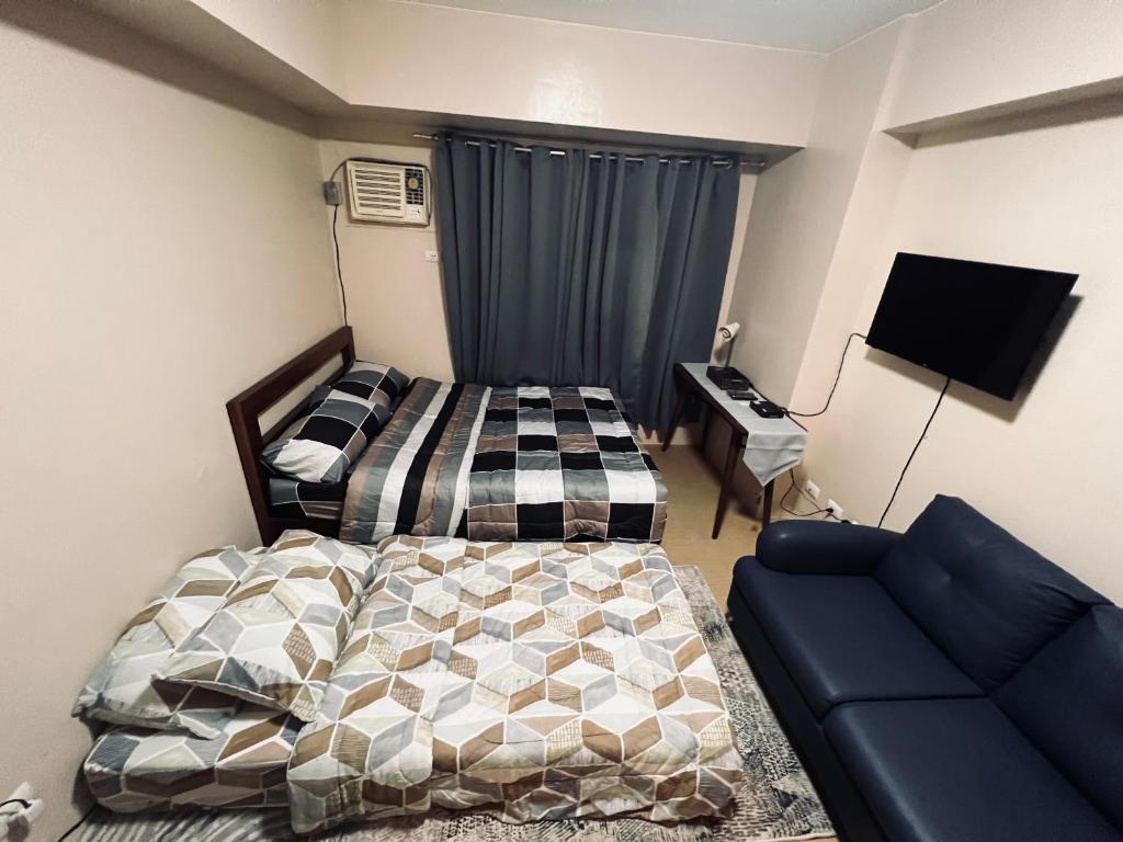 ein Schlafzimmer mit einem Bett und einem Sofa in der Unterkunft B Avida Tower in Iloilo City