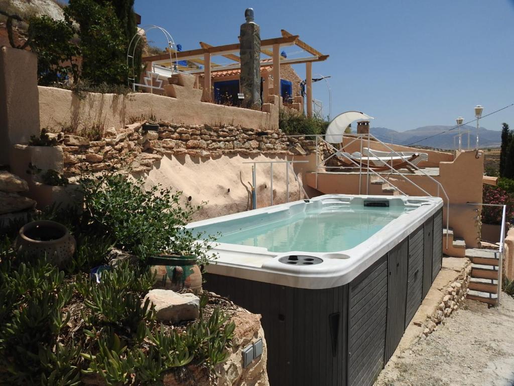 a hot tub in a yard with a building at Cuevas La Veranda in Orce