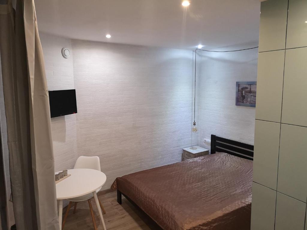 Cette petite chambre comprend un lit, une table et un lavabo. dans l'établissement Freedom apartment on Bazarna str, à Lviv