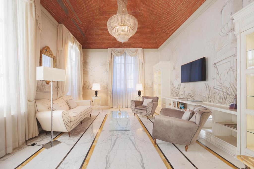 Hotel Embassy في فلورنسا: غرفة معيشة مع أريكة وكراسي وتلفزيون