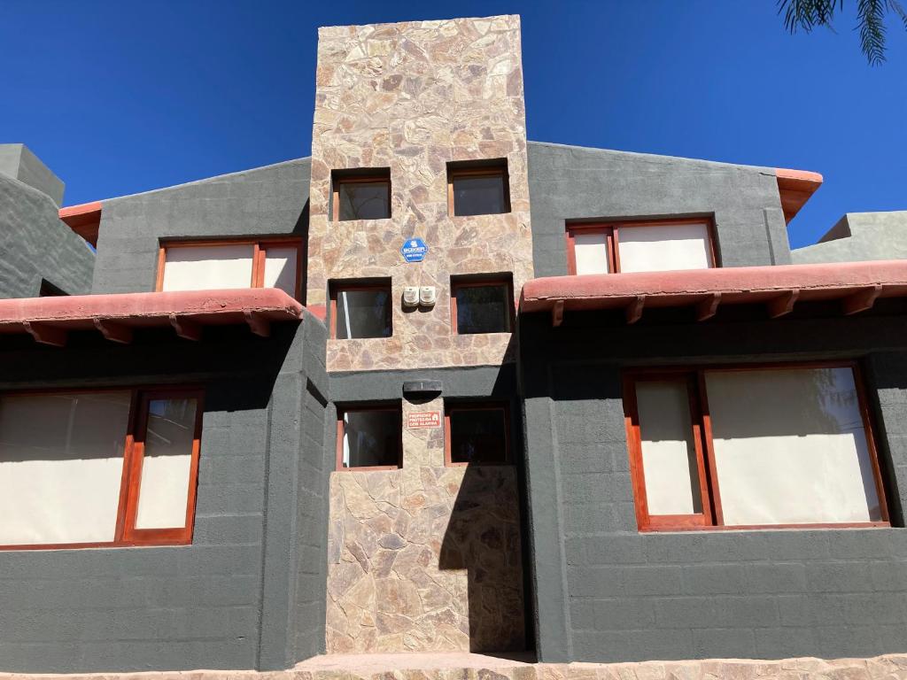 a building with a stone facade with a blue sky at Cabañas La Sorpresa in Tilcara