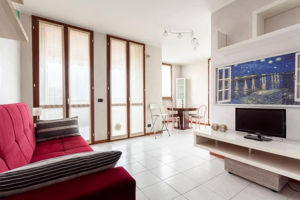 a living room with a red couch and a tv at Forum Assago appartamento in Assago