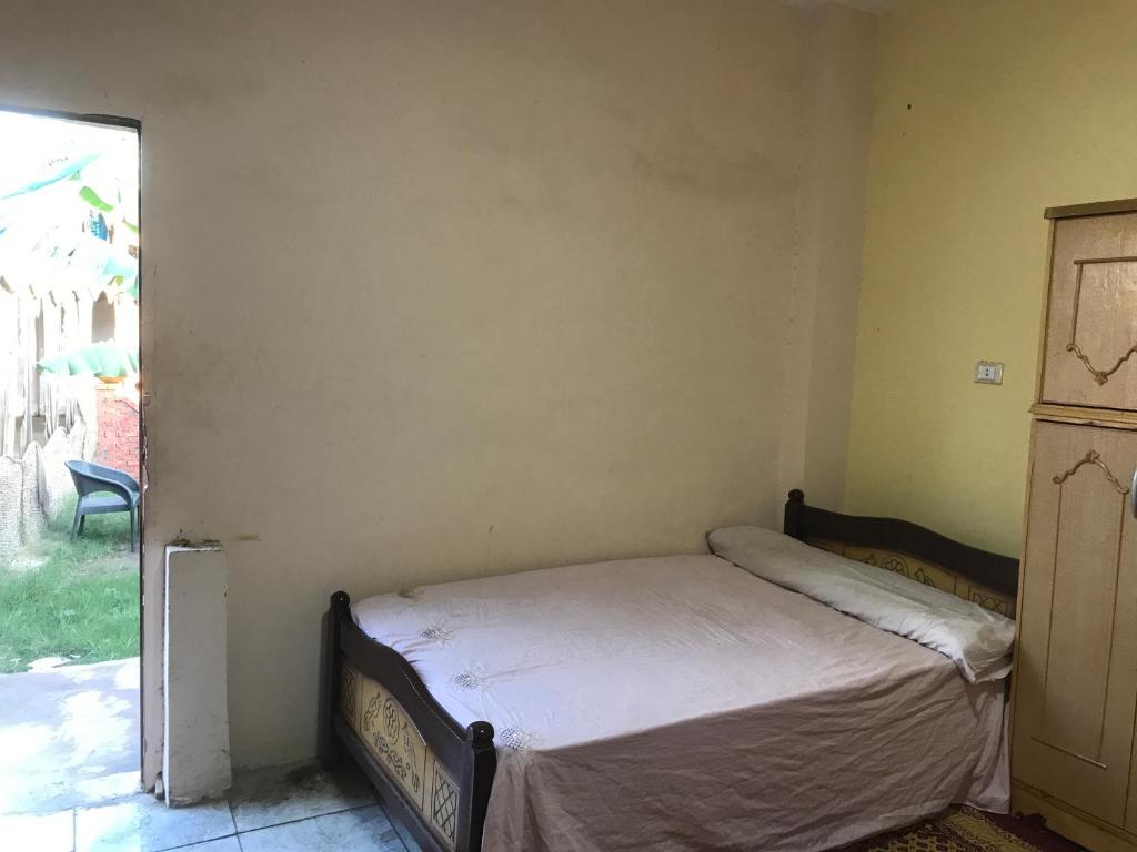 Un pequeño dormitorio con una cama en la esquina en Ahmed XCafe, en Minshāt Dahshūr