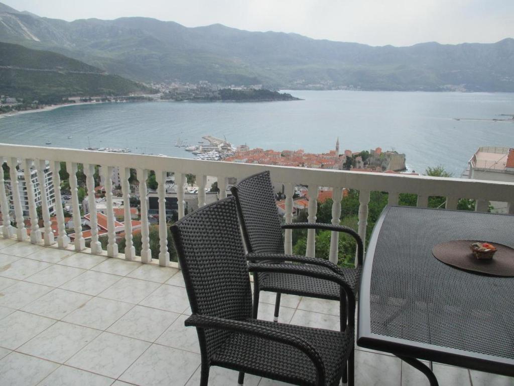 einen Balkon mit einem Tisch und Stühlen sowie Blick auf das Wasser in der Unterkunft TOP view Apartment Budva in Budva