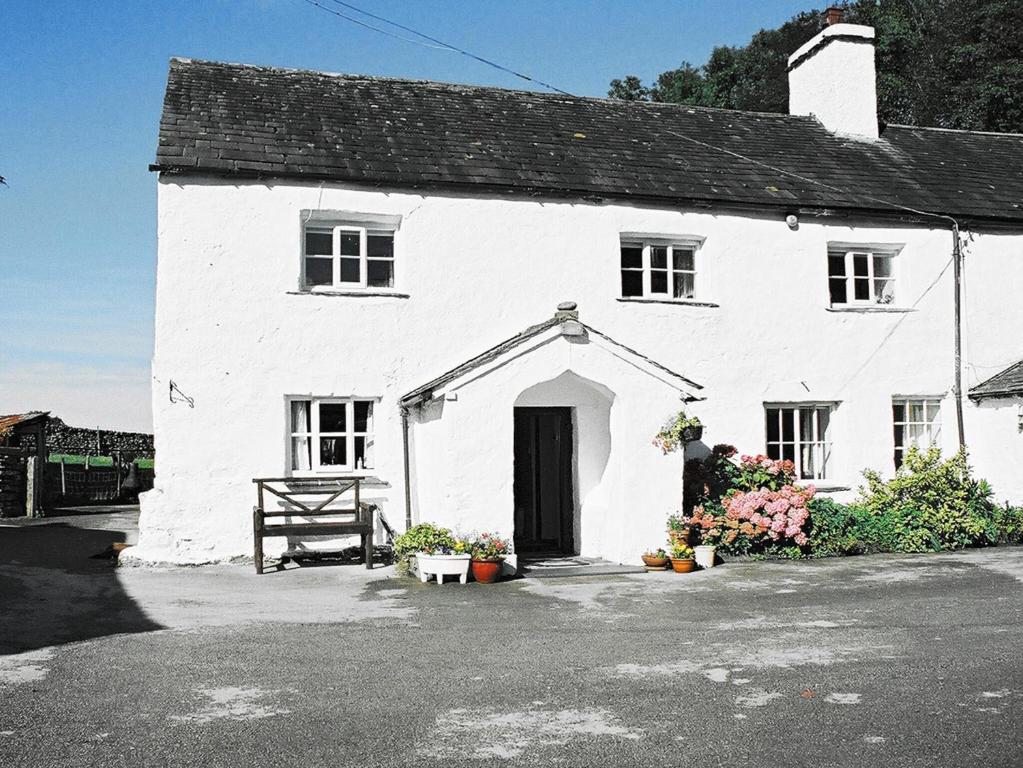 a white house with a black roof at Barker Knott Farm Cottage in Bowness-on-Windermere