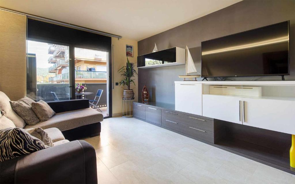 a living room with a couch and a flat screen tv at Josep Mº Folch Centro in Tossa de Mar