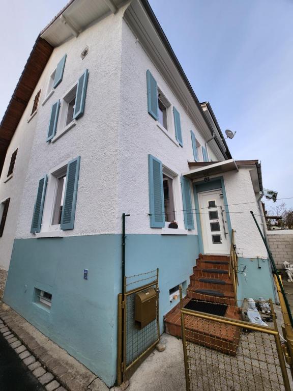 a white and blue house with blue shutters at Gästezimmer Sakowski in Lörrach