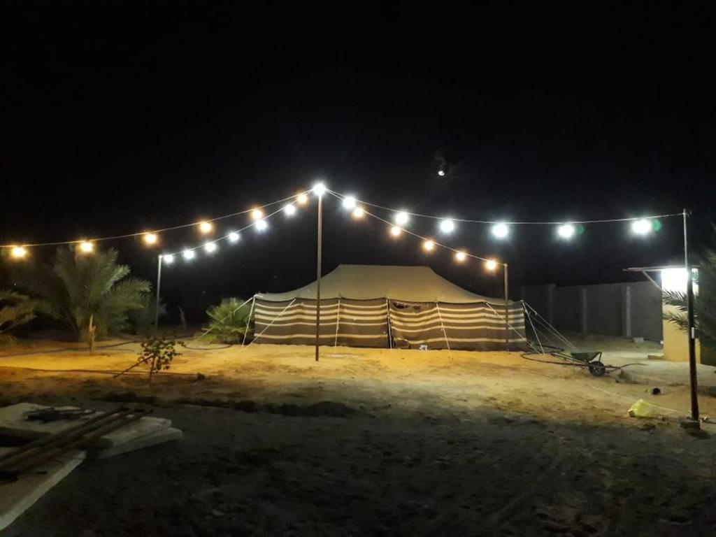 una tienda de campaña con luces por la noche en مزرعة الطيبين, en Buraidah