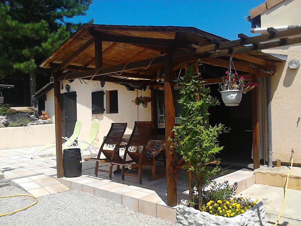 a wooden pergola with chairs on a patio at LE CHAMOIS DORT in Die