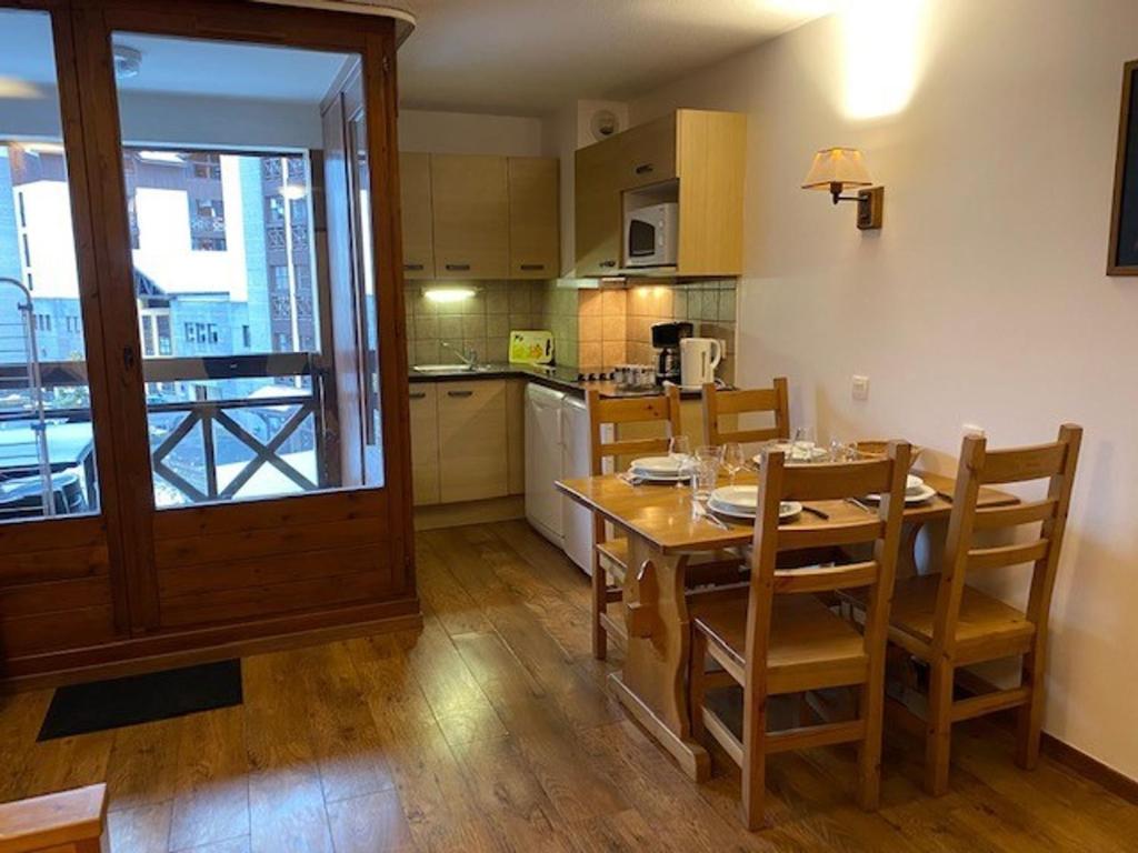 une cuisine et une salle à manger avec une table et des chaises dans l'établissement Studio chaleureux à Brides les Bains - 4 pers, 28 m², balcon, parking, proche thermes - FR-1-512-252, à Brides-les-Bains