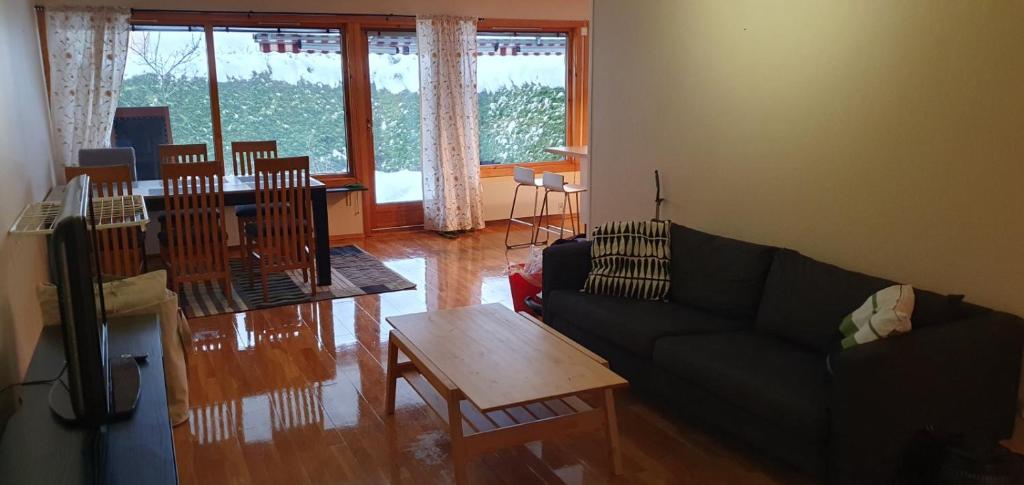 a living room with a couch and a table at Leilighet(75m²)+hage(40m²) 20 min fra sentrum in Grorud