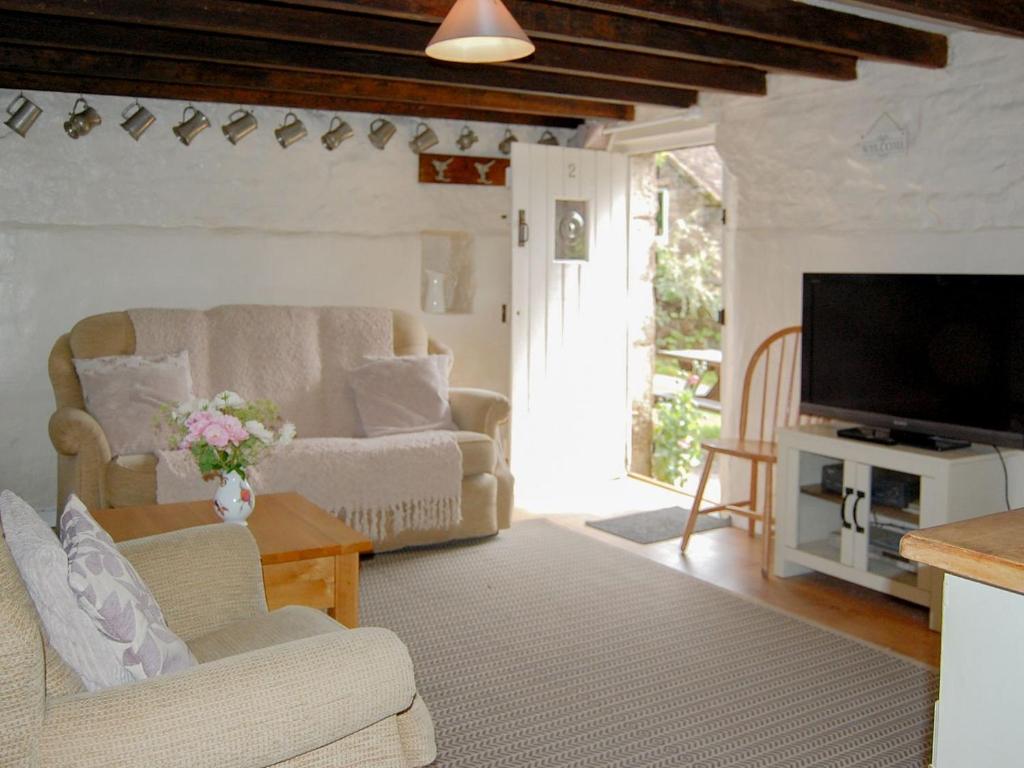 ein Wohnzimmer mit einem Sofa und einem TV in der Unterkunft Nightingale Cottage - Ukc1570 in Crich
