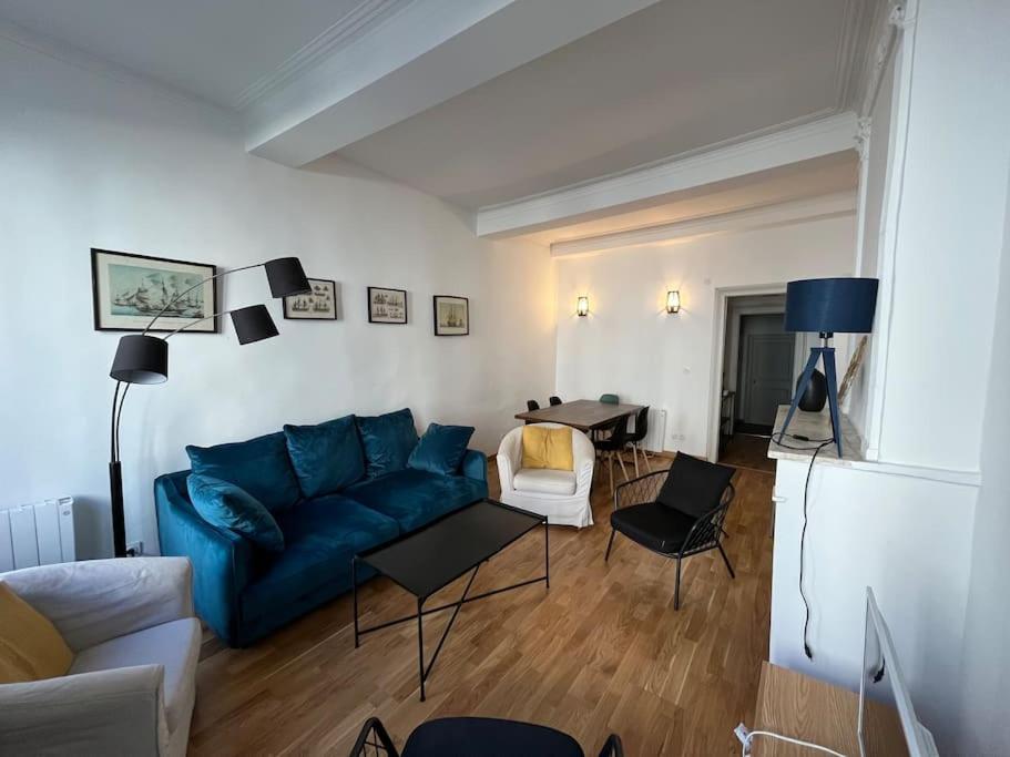 a living room with a blue couch and a table at La Comédie, appart de Charme in Montpellier