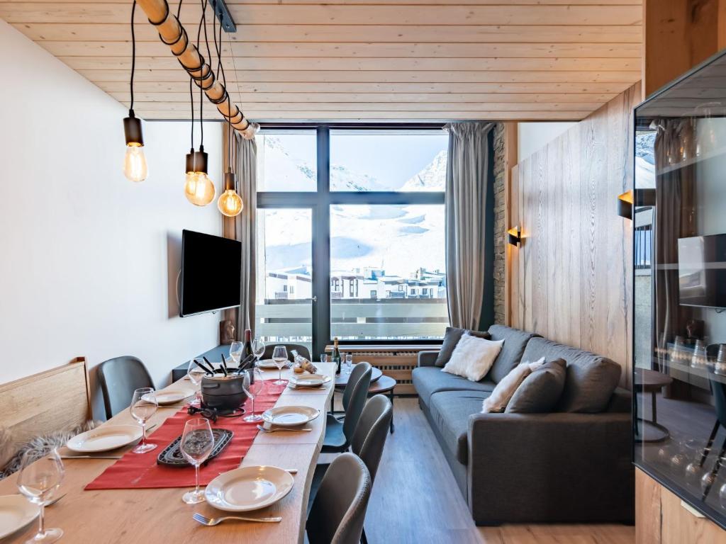 a living room with a table and a couch at Apartment Les Hauts du Val Claret - Val Claret-23 by Interhome in Tignes