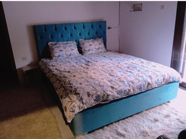 a bed with a blue headboard in a bedroom at Breakfast & Snacks, 2bedrooms 2bathrooms House in Kato Zachlorou