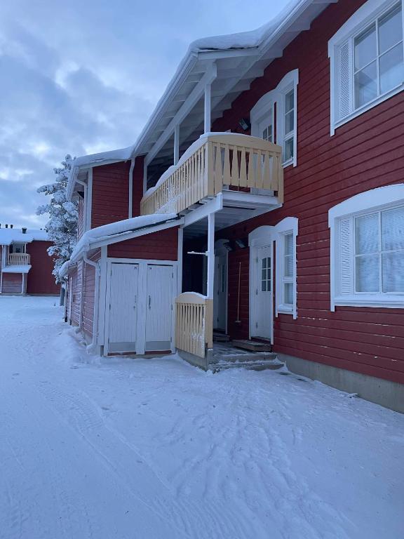 a red house with a deck on the side of it at Outapailakka K19 in Saariselka