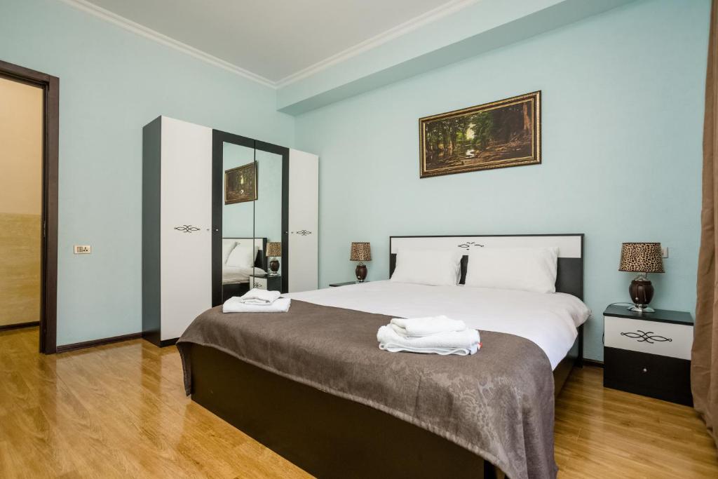 a bedroom with a large bed with two towels on it at Rustaveli Three Bedroom Apartment with Amazing views in Tbilisi City