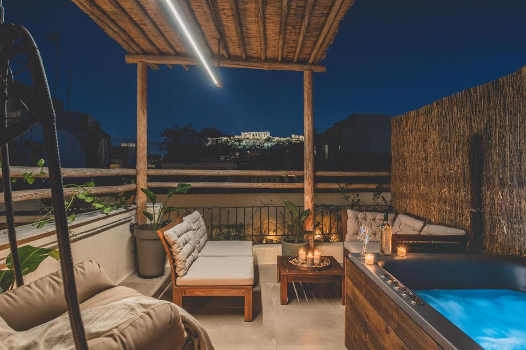 patio con bañera, sofá y mesa en Luxury Apartment with Acropolis View Terrace and Jacuzzi - Living Stone Moonstone, en Atenas
