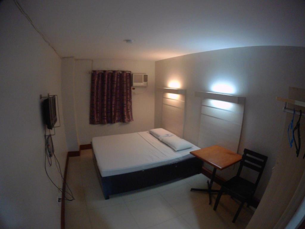 カガヤン・デ・オロにあるD' Loft Inn CDOのベッドと小さなテーブル付きの小さな部屋