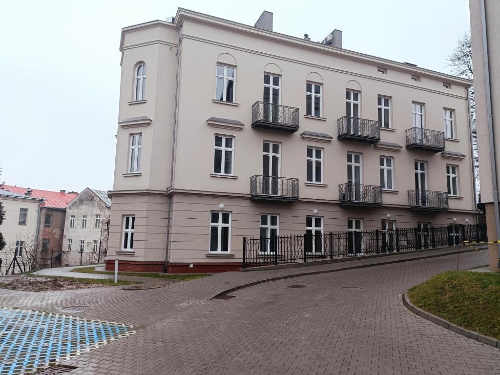 biały budynek z balkonami przy ulicy w obiekcie Apartamenty na Poddaszu- Tatarska 4 w mieście Przemyśl
