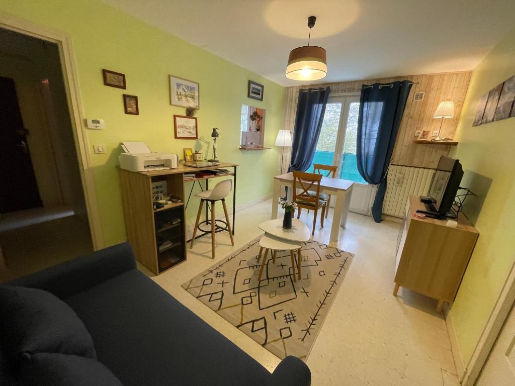 ein Wohnzimmer mit einem Sofa und einem Tisch in der Unterkunft Appartement Cap Vern Les Bains in Capvern