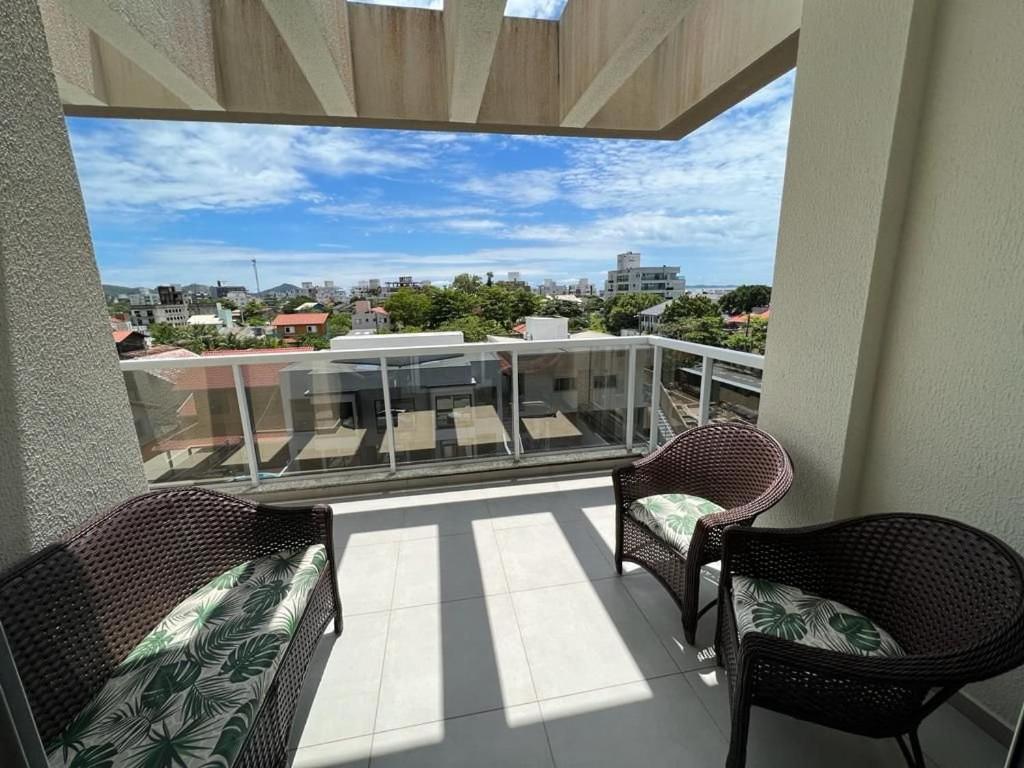 balcón con 2 sillas y vistas a la ciudad en Duplex Byron Beach Residence, en Bombinhas