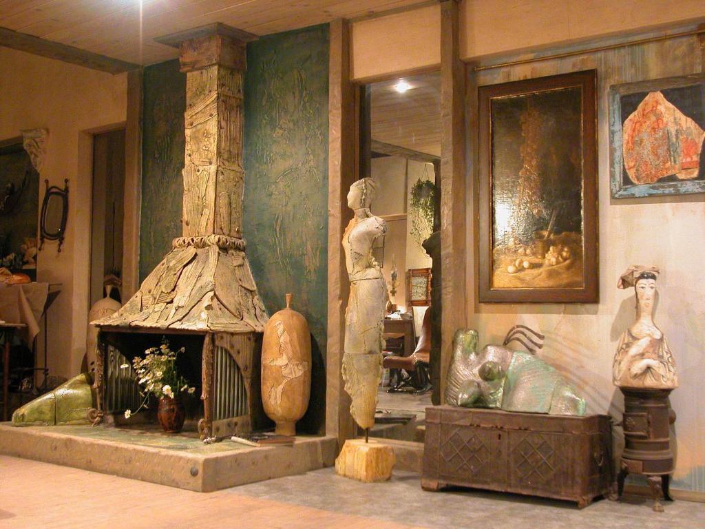 トビリシにあるギャラリー アーティスト ハウスの暖炉付きの部屋、床に花瓶が数本