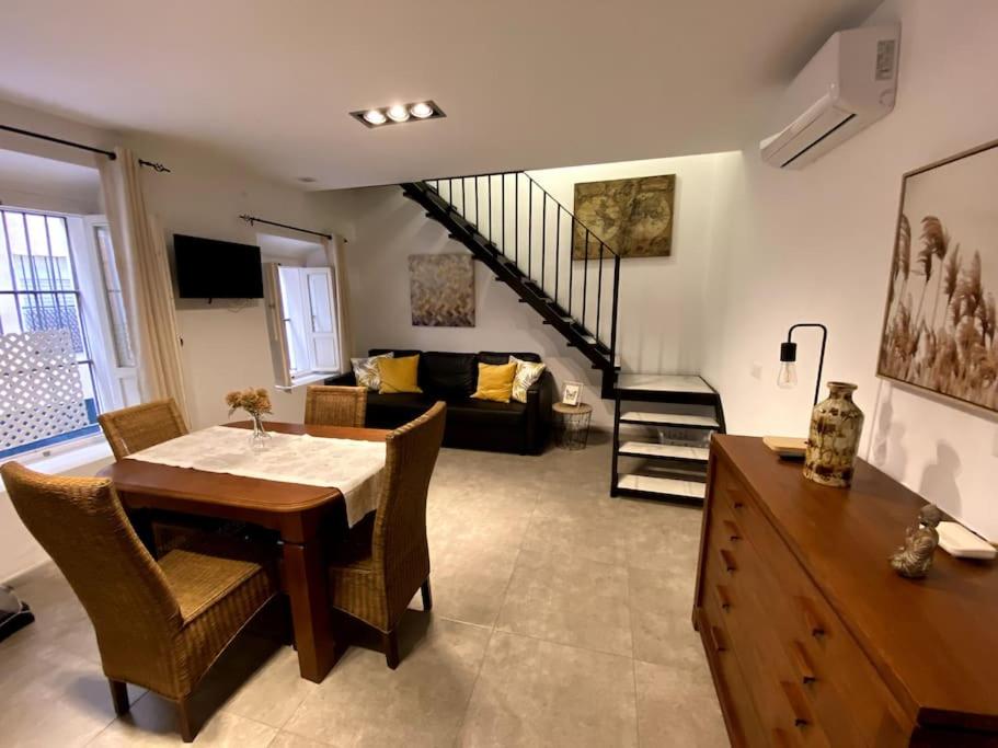 ein Wohnzimmer mit einem Tisch und einem Sofa in der Unterkunft Moderno duplex en la Tacita de Plata in Cádiz