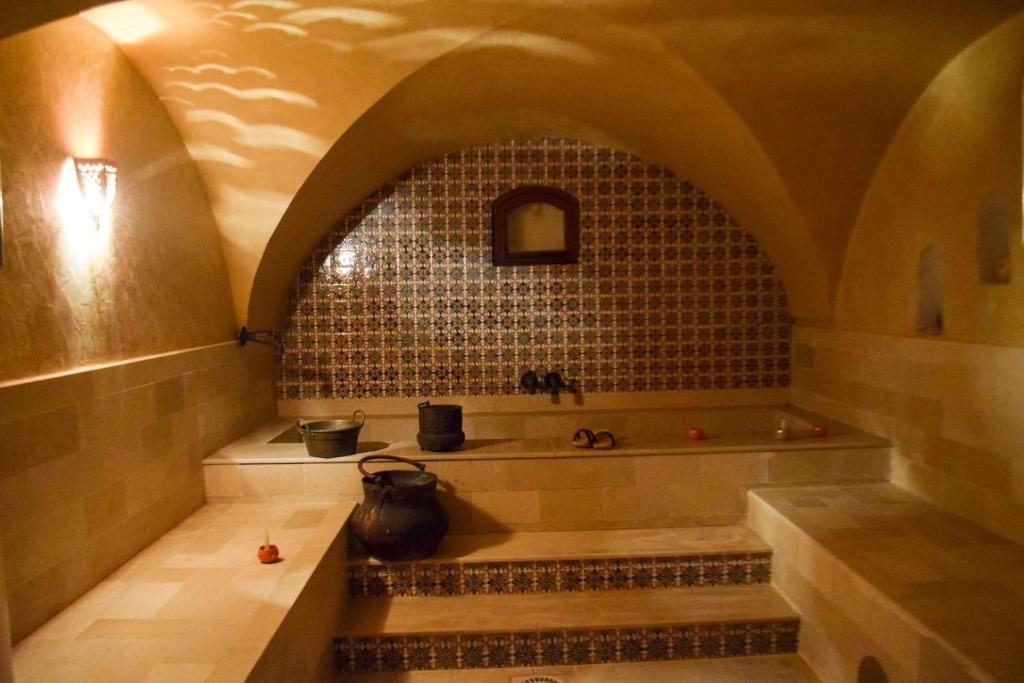 a bath tub in a room with a tile wall at DAR BELDI in Hammamet