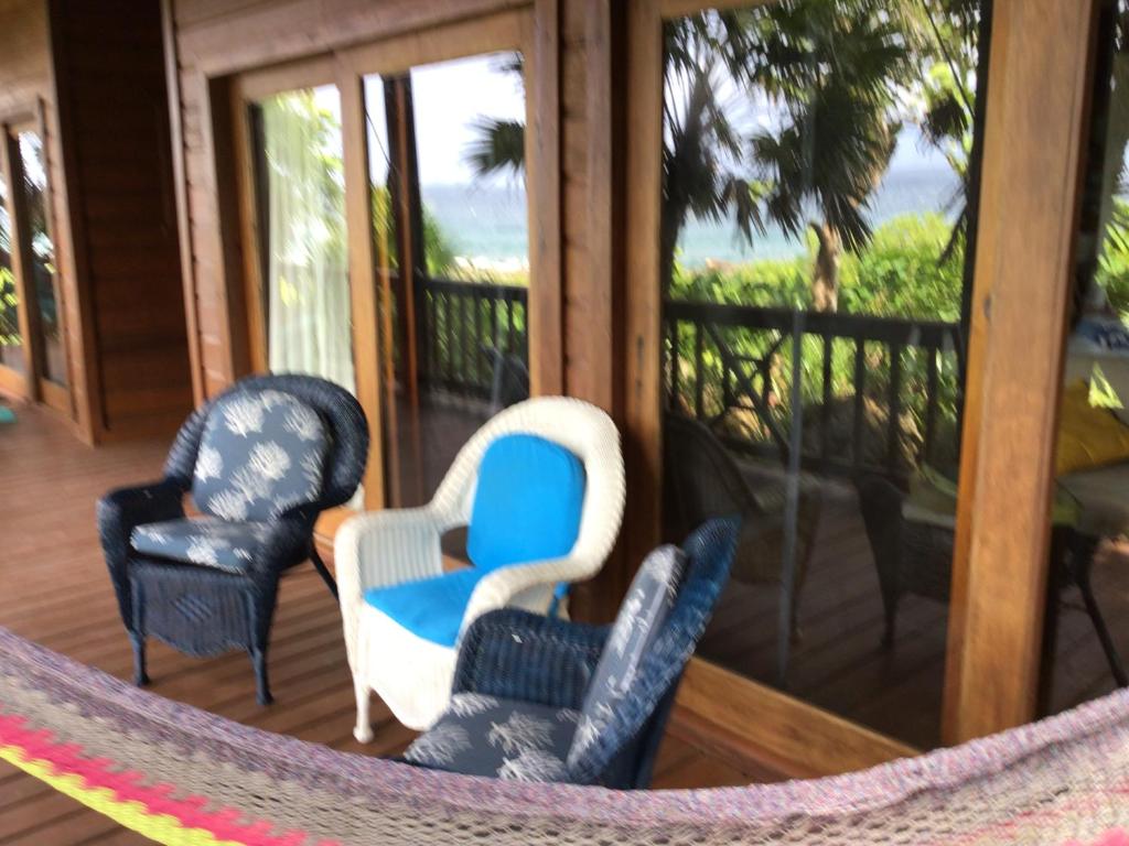 three chairs and a hammock on a porch at Cocolobo Resort in West End