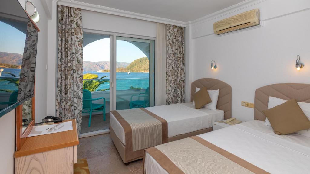 een hotelkamer met 2 bedden en een balkon bij Contess By Faros in Marmaris