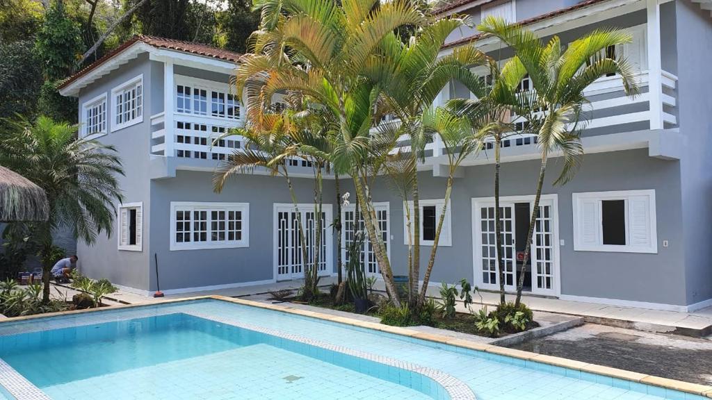 聖塞巴斯蒂安的住宿－Linda casa na Barra do Sahy 1 (Litoral Norte SP)，一座别墅,在一座建筑前设有一个游泳池
